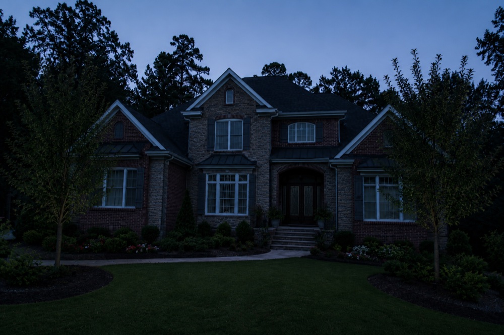 The same golf-community home facade at dusk before architectural uplighting was installed