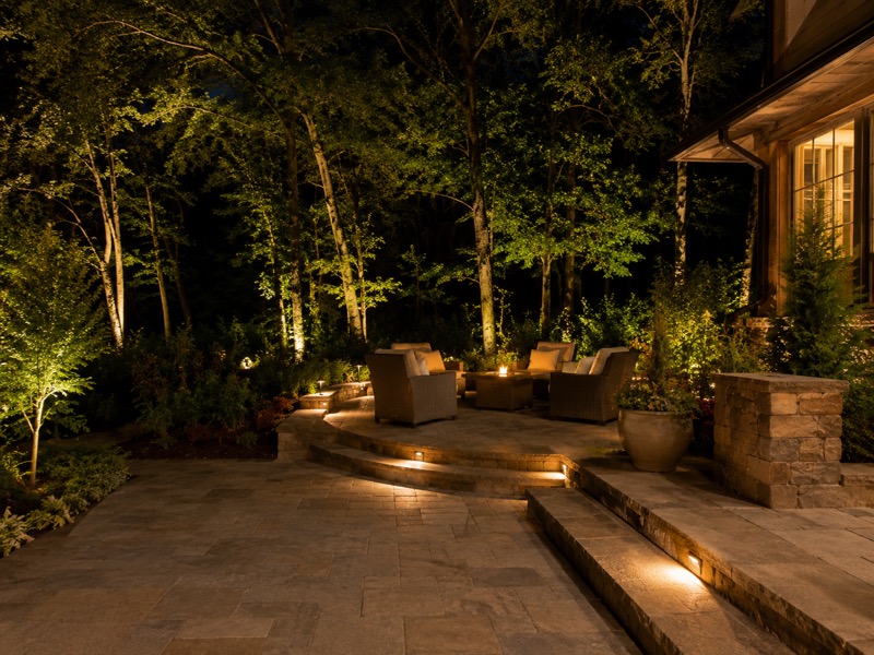 Troutman new-construction backyard patio and garden beds lit at night with warm low-voltage lighting (design concept)